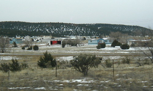 Some little town in New Mexico, the snow is getting closer to the road.